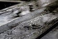 Rain drop splash in wooden floor bouncing and shaping a water crown Royalty Free Stock Photo