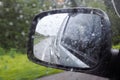 Rain drop on wing mirror or outside mirror of car while driving on road in rainy day. Drive carefully in rainy day