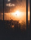 Rain Droplets on Glass Window with Blurry Golden Orange Light Background Royalty Free Stock Photo