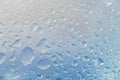 Rain droplets. Spilled water drops on glass, natural blue background. Royalty Free Stock Photo