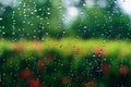 Rain droplets on surface of car glass with blurred green nature background through window glass of car covered by raindrops. Royalty Free Stock Photo