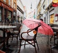 Rain drops Autumn yellow leaves  on window view on street with cafe table and umbrella in Tallinn old town travel to Estonia Royalty Free Stock Photo