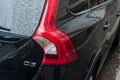 rain drops on black new Volvo on rear view parked in the street