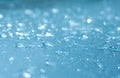 Rain drops on the blue glass bokeh background, shiny raindrops on a glass surface, water drops in a swimming pool closeup Royalty Free Stock Photo