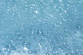 Rain drops on the blue glass bokeh background, shiny raindrops on a glass surface, water drops in a swimming pool closeup Royalty Free Stock Photo