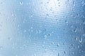 Rain drops on the blue glass bokeh background, shiny raindrops on a glass surface, water drops in a swimming pool closeup Royalty Free Stock Photo