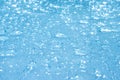 Rain drops on the blue glass bokeh background, shiny raindrops on a glass surface, water drops in a swimming pool closeup Royalty Free Stock Photo