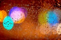 Rain drops on car window with road light bokeh Abstract night city life background at night during rainy season Royalty Free Stock Photo