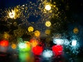 Rain drops on car window with road light bokeh on rainy season abstract background Royalty Free Stock Photo