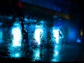 Rain drops on car window with road light bokeh on rainy season abstract background Royalty Free Stock Photo
