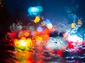 Rain drops on car window with road light bokeh on rainy season abstract background Royalty Free Stock Photo