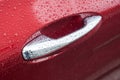 rain drops on chromed handle of red luxury car Royalty Free Stock Photo