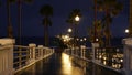 Rain drops, evening in Oceanside California USA. Pier, palms in twilight dusk. Reflection of light.