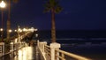 Rain drops, evening in Oceanside California USA. Pier, palms in twilight dusk. Reflection of light.