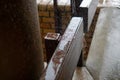 Rain drops falling on a brown railing. Drops creating splashes and ripples.