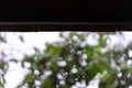 Rain drops falling from roof with bokeh background Royalty Free Stock Photo