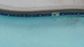 Rain drops falling on water of swimming pool, rainy in California motel or hotel