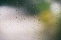 Rain drops on glass - Rainy day window glass with water drops and nature green blur background , selective focus Royalty Free Stock Photo