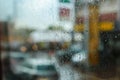 Rain drops on glass and street cars in background, focus on water. Royalty Free Stock Photo