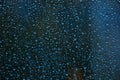 Rain drops on glass surface as background. Dark blue abstract backdrop. Royalty Free Stock Photo