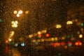 Rain drops on glass surface with bokeh night city lights from lanterns Royalty Free Stock Photo