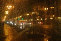 Rain drops on glass surface with bokeh night city lights from lanterns Royalty Free Stock Photo