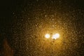 Rain drops on glass surface with bokeh night city lights from lanterns Royalty Free Stock Photo