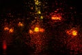 Rain drops on glass surface with red bokeh night city lights from a lanterns, car, shops Royalty Free Stock Photo