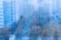 Rain drops on the glass window. night rainy window in autumn spring summer. abstract natural view. rainy season. droplets on blue Royalty Free Stock Photo