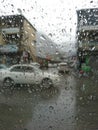 Rain drops on glass after rain. City view in Blurred background. Mountains area