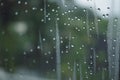 Rain drops during raining in rainy day outside window glass with blurred background with water droplet flow down the surface Royalty Free Stock Photo