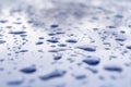 Rain drops on the red car surface. Water srops on car hood. Water drops on blue metal surface. Royalty Free Stock Photo