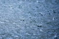 Rain drops rippling in a puddle with blue sky reflection Royalty Free Stock Photo