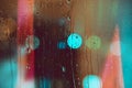 Rain drops run down the window with colorfull lights of the nitht city. Abstract background of night city life. Royalty Free Stock Photo