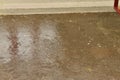 Rain drops on the surface of water in the floor with graduated shade of black shadow and reflection of blue sky Royalty Free Stock Photo