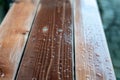 Rain drops on a varnished wooden bench