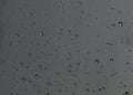 Rain drops, water drops of rain on a window glass with blurred dark background Royalty Free Stock Photo