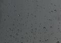 Rain drops, water drops of rain on a window glass with blurred dark background