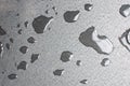 Rain drops of water-repellent surface in black and white on grey background. Close up macro Royalty Free Stock Photo