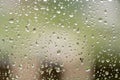 Rain drops on window with building and green tree in background Royalty Free Stock Photo