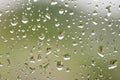Rain drops on window with building and green tree in background Royalty Free Stock Photo