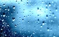 Rain. Drops on the window. Close on the glass. Shower. Wet glass. Blue background.