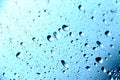 Rain. Drops on the window. Close on the glass. Shower. Wet glass. Blue background.