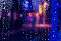 Rain drops on the window. Colorful street lights on the rain. Blurred abstract background. Royalty Free Stock Photo