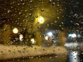 Rain drops on window with dark street bokeh lights. Royalty Free Stock Photo