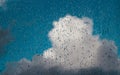 Rain drops on a window glass with big cloud on a backside