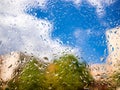 Rain drops on the window glass. Blurred background with house, greenery, clouds and blue sky Royalty Free Stock Photo