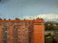 rain drops on a window pane against city view in a rainy day Royalty Free Stock Photo