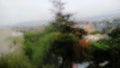 Rain drops on a window pane with blurred tree in background Royalty Free Stock Photo