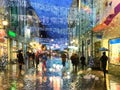rain in the  City, Christmas street  night light blur  ,people walking with umbrellas , rain drops reflection on windows vitrines Royalty Free Stock Photo
